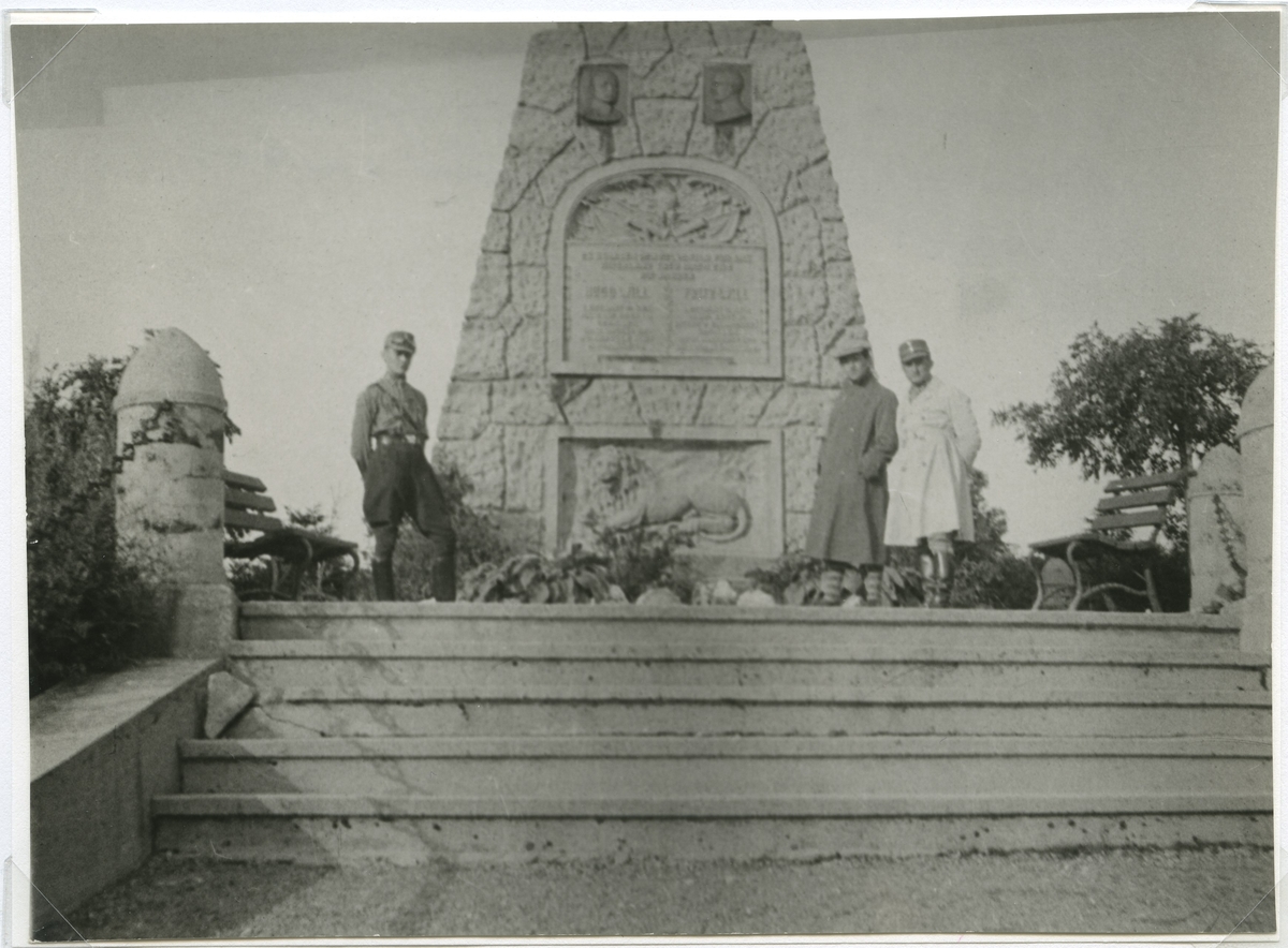 Hovfotograf Walter Olson, Kalmar, tillsammans med två tyska SA-män vid ett monument nära Sommerbachskopf i Tyskland.
Monumentet är ett gravkomplex på den 931 m höga Sommerbachskopf, byggt av handelsråd Oskar Will, ägare till Venus vapenfabrik, till minne av hans söner Hugo Will 1914 och Fritz Will 1914 som dog i första världskriget. Den byggdes av byggmästare Lange från Mehlis och företagen Bieräugel från Zella St Blasii och Günther och Wendel från Suhl. Begravningen ägde rum den 22 augusti 1915 med stort deltagande från befolkningen. Gravkomplexet har en bred trappa och en matt, starkt lysande sandstenspyramid, som bär bibelversen krönt med eklöv: ”Ingen har större kärlek än denna, att han ger sitt liv för sina vänner. . Ev. Joh 15 v. 13 Vila i frid.”, inskriptionen med de fallnas namn och en relief som visar lejonet från Thermopylae syns. 1998 totalrenoverades graven av staden Zella-Mehlis.