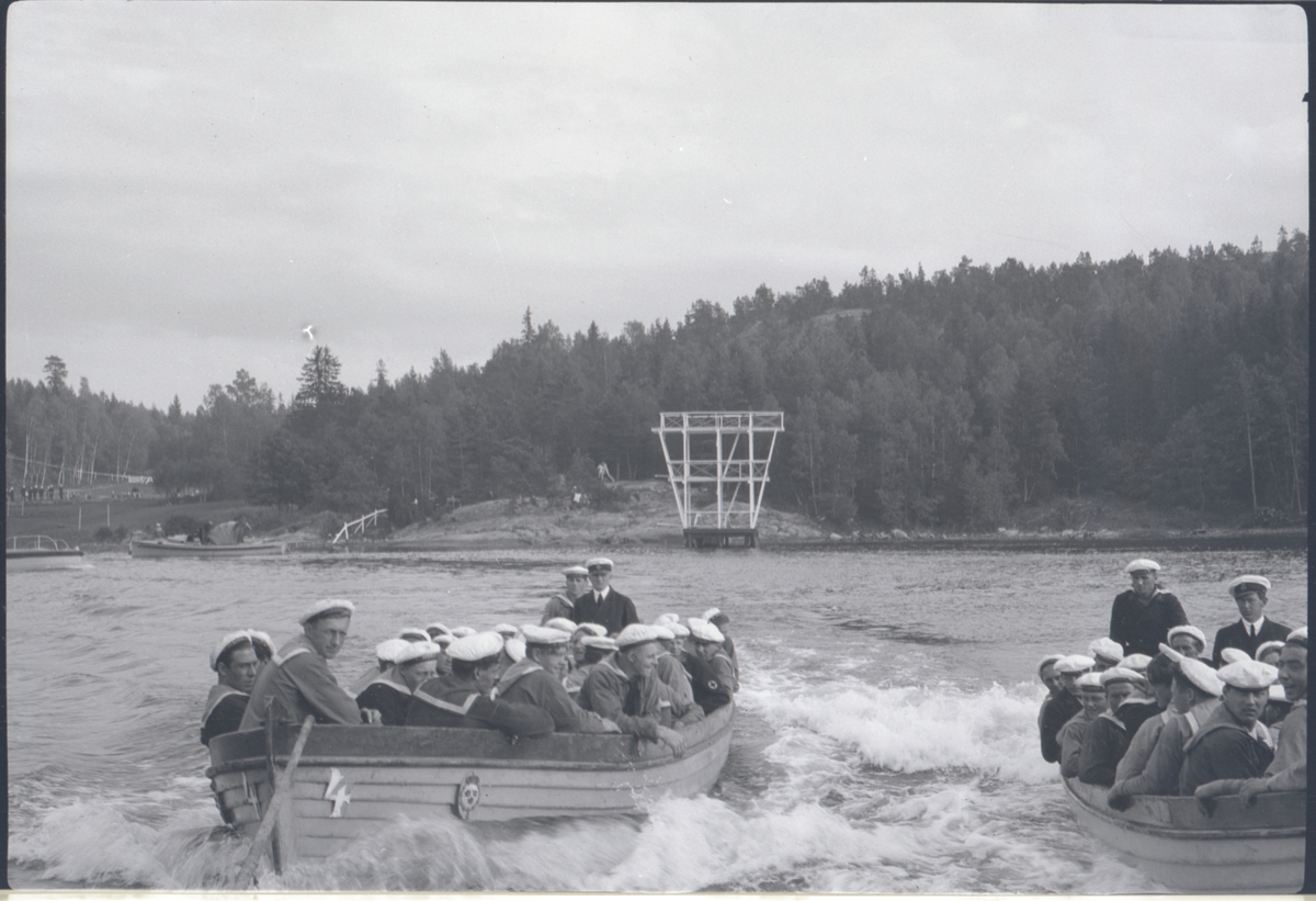 Matroser från pansarskeppet SVERIGE bogseras 1929 tillbaka till fartyget i slupar efter att ha besökt idrottsanläggning på Vitsgarn vid Hårsfjärden.