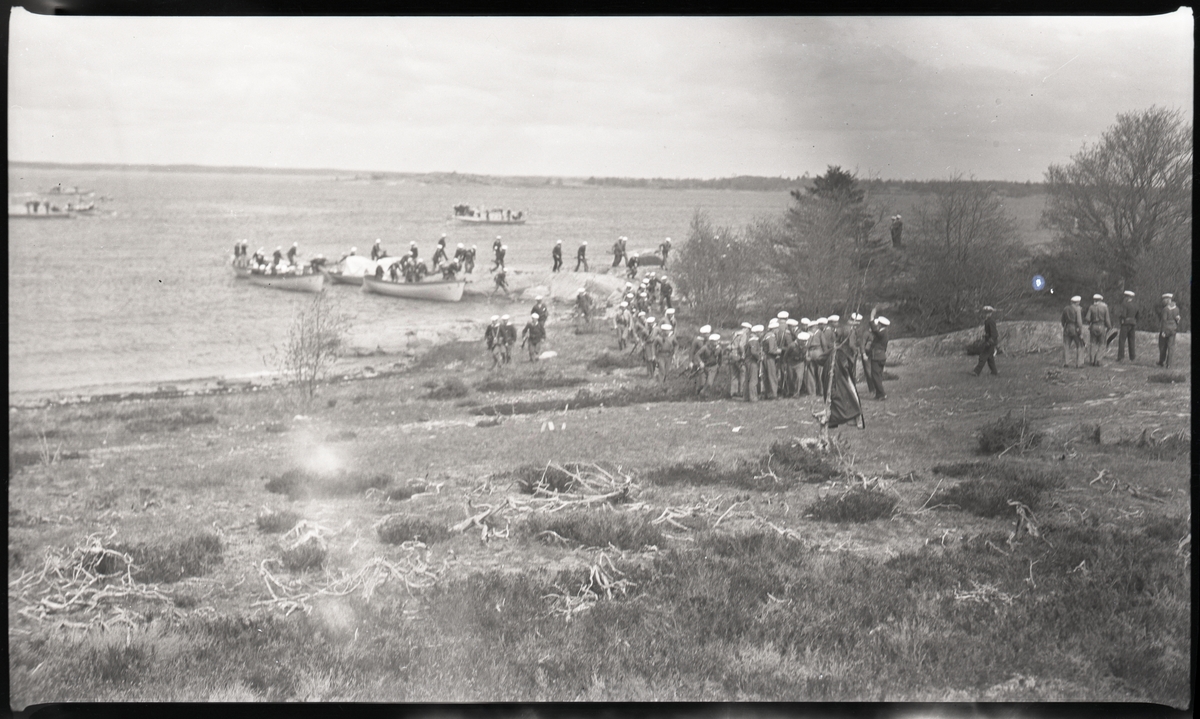 Landstigning på skärgårdsö. Andra bilder i Bergers samling tyder på att detta fotografi tagits då manskap från pansarskeppet SVERIGE deltog i stridsövning på Stabbo i Stockholms södra skärgård 1929, detta har dock inte kunnat bekräftas.