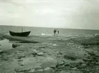 Båt fastgjord vid i flisan nersatt stång för att icke tagas av sjön. Denna strandflisa som översköljes av vågorna kallas 