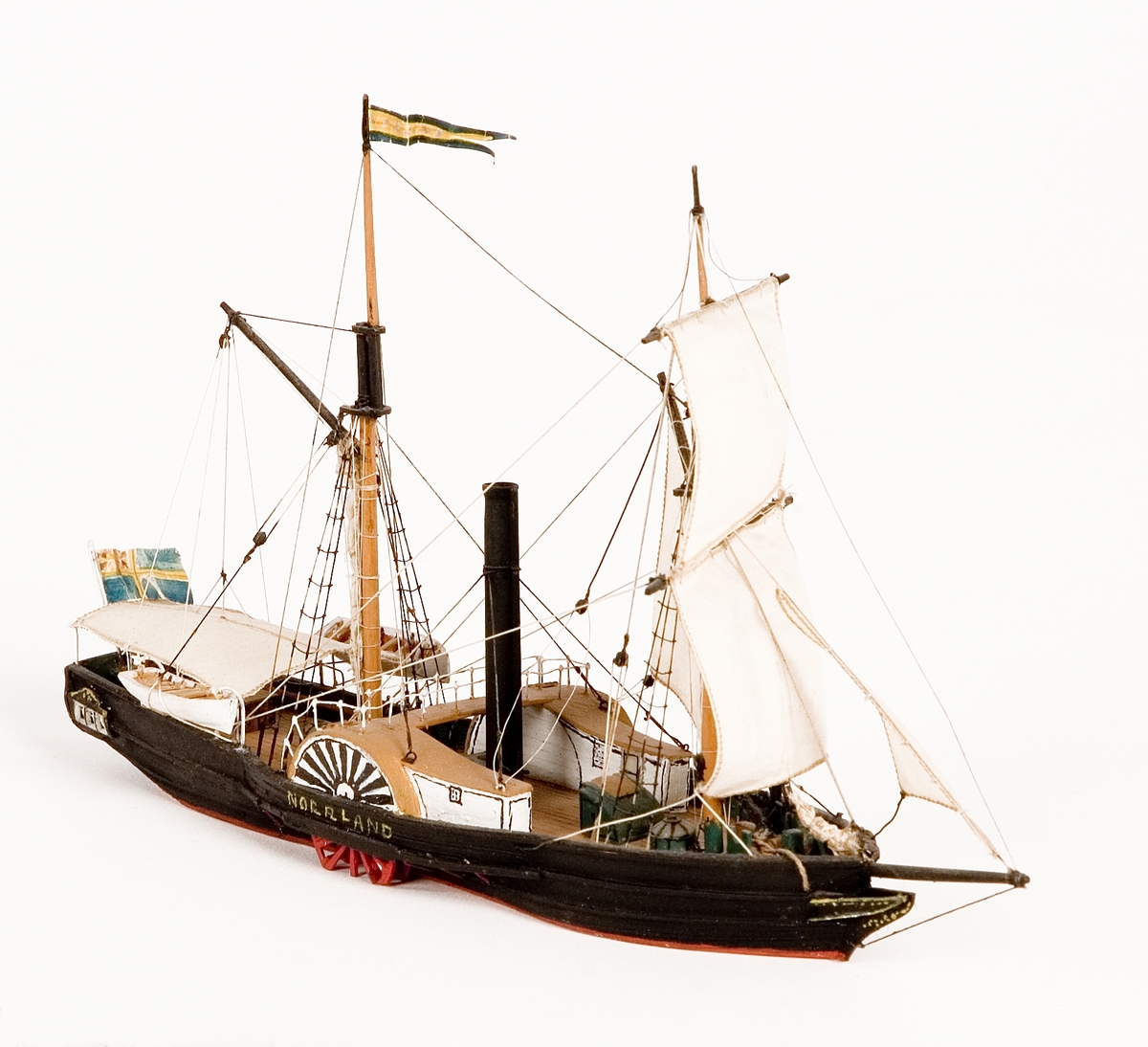 Fartygsmodell på vattenlinje. Hjulångaren "Norrland", hel i block av trä. Fartyget är skonertriggat med segel av bomull. Blå och gul namnvimpel på stortopp och svensk flagga med unionsmärke akterut. I aktern fyra fönster. Fartygsfakta:

60   hkr.

Reg. nr. Sthlm   5    ( SE. 1839)
Föremålets form: Vattenlinjemodell