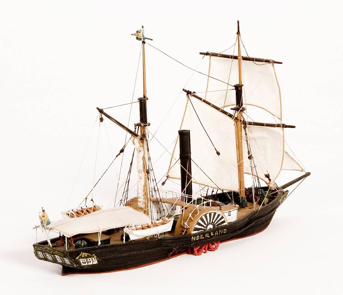 Fartygsmodell på vattenlinje. Hjulångaren "Norrland", hel i block av trä. Fartyget är skonertriggat med segel av bomull. Blå och gul namnvimpel på stortopp och svensk flagga med unionsmärke akterut. I aktern fyra fönster. Fartygsfakta:

60   hkr.

Reg. nr. Sthlm   5    ( SE. 1839)
Föremålets form: Vattenlinjemodell