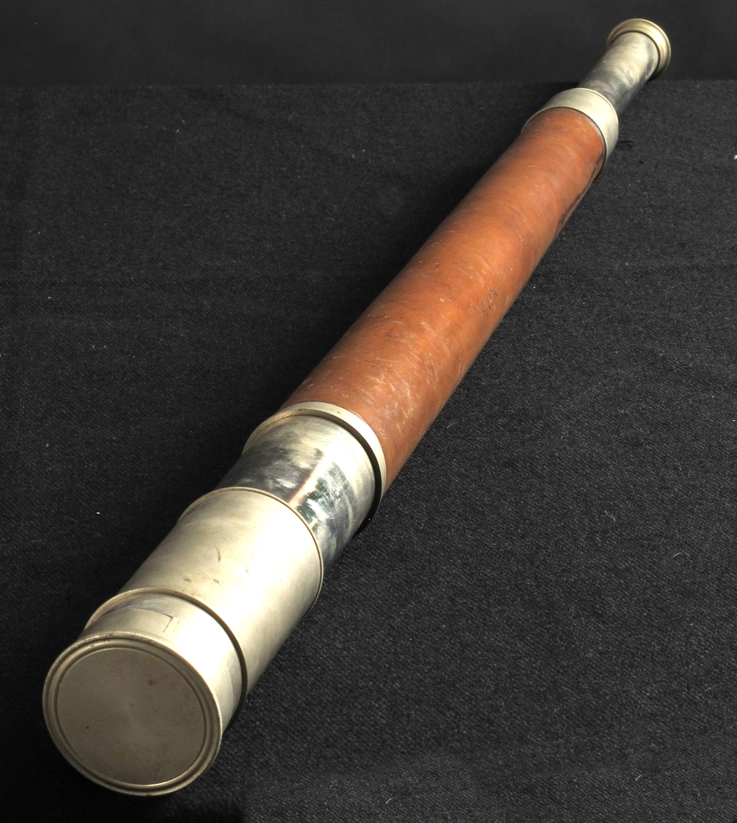 Langkikkert,  laget av  Troughton & Simms, London, 1863.  
a) Kikkert.   Forkrommet   metall,  brunt skinn. Lang sylinder med forkrommet del i hver ende, kanelbrunt skinn pm.  Når den smale ende trekkes ut, kommer flg. tekst til syne: 

" Presented by the British Government to Captain J. M. Smith, Master of the Norwegian Barque "Solon" of Arendal,   in acknowledgement of his humanity and kindness to the   Master and Crew on the Barque "Lemuel" of Souht Shields,  whom he rescued from their sinking Vessel on the 22nd   September 1863."  Under: " Troughton & Simms, London."  

b) Etui.   Mahogni  med litt grønn filt.  Langt etui med flatt lokk og to   messing  kroker i siden. Nedsenket felt med avskårne hjørner midt på lokket,  har vært pålimt etikett med tekst iflg. protokoll: Captain J. M. Smith. 

Tilstand febr. 1967: kikkerten god. Etuiet en del oppskrapet i toppflaten.