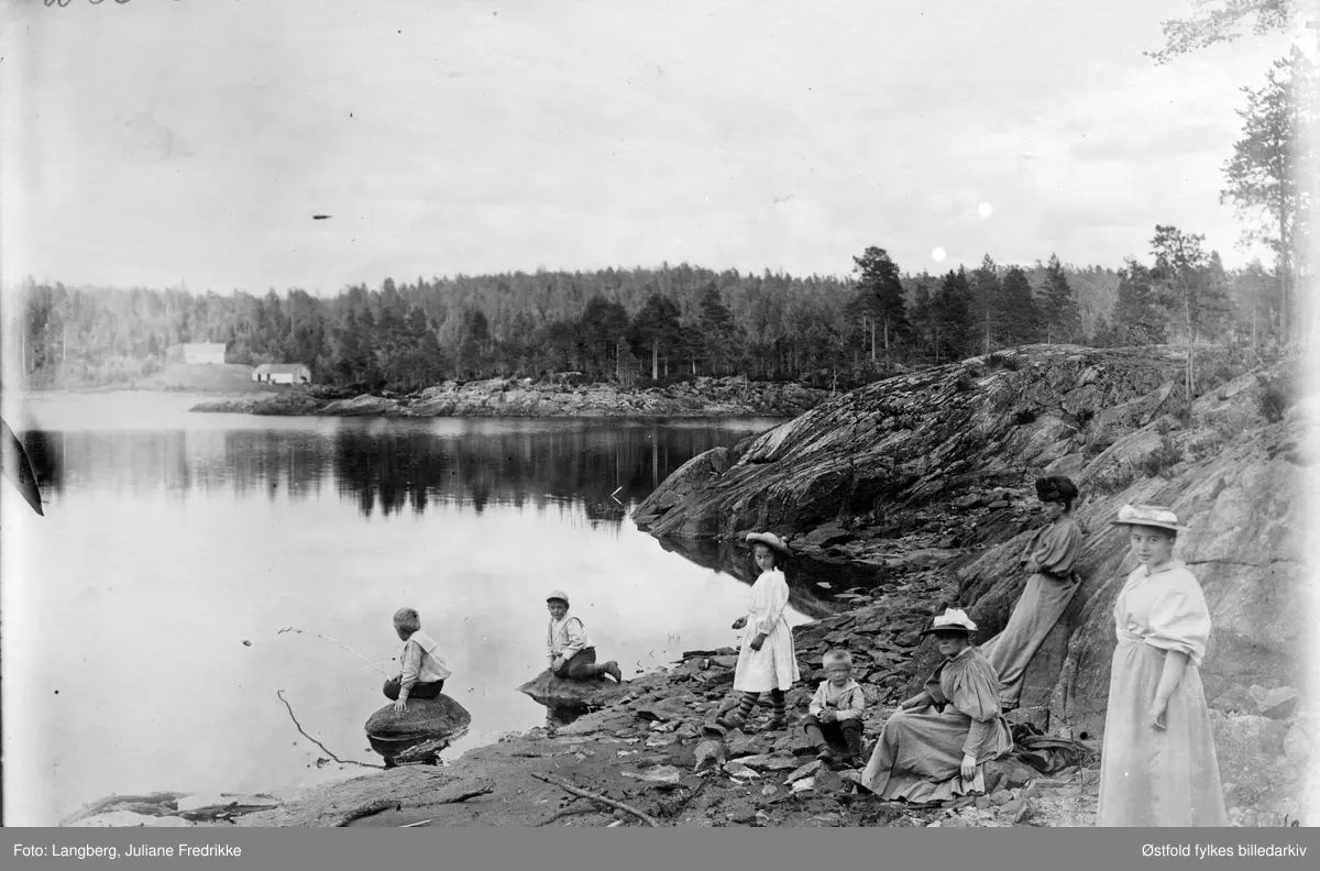 Fisketur et sted i Rakkestad. Barna til Louise Langberg og prest  Olaf Andreas Holm, som bodde på Bergenhus kapellangård i Rakkestad, ca. 1895.  Ukjent gårdsbruk i bakgrunnen.
Barna er fotografert av sin tante (mors søster).
Fra venstre (antatt):
Olaf f. 1887
Kristoffer Gerhard f. 1889
Emily f. 1886
Christian Lorentz f. 1892
NN
NN
Margrethe f. 1877
En av de voknse kvinnene kan være Louise Langberg Holm, mor til barna.
