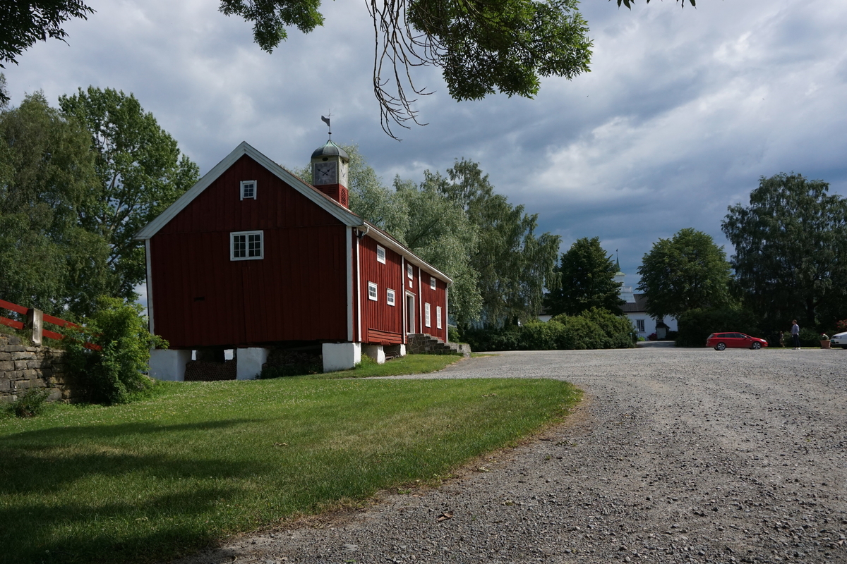 Hovinsholm, Nes, Ringsaker. 
Lukket klokketårn med illuderte urskiver på fire sider. Klokketårnet har et lavt hjelmformet kobbertak. Tårnet er plassert på en rød sokkel.