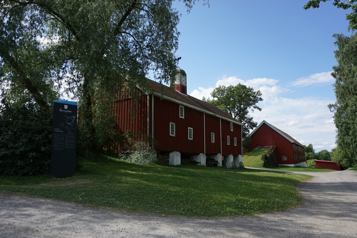 Hovinsholm, Nes, Ringsaker. 
Lukket klokketårn med illuderte urskiver på fire sider. Klokketårnet har et lavt hjelmformet kobbertak. Tårnet er plassert på en rød sokkel.