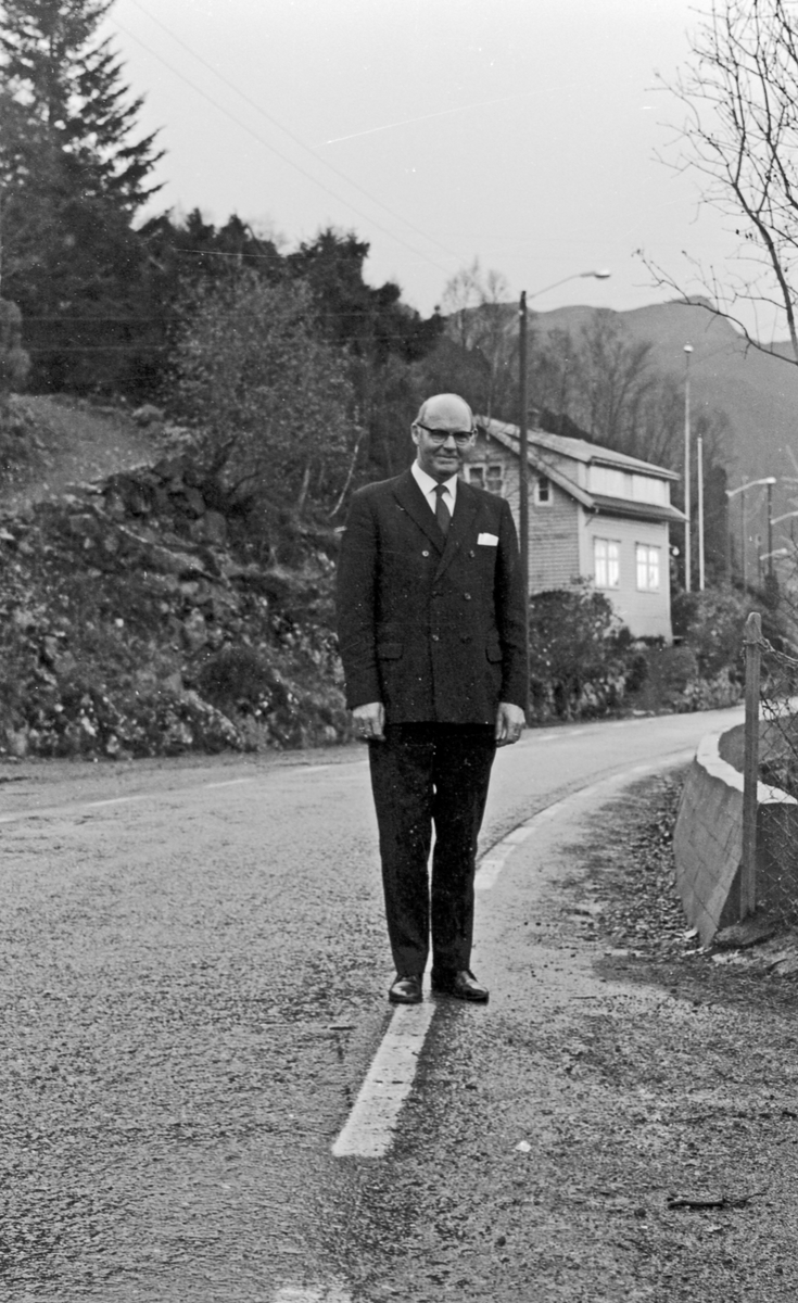 Voksen mann som poserer ved en øde landevei. Holder et nett i handen.