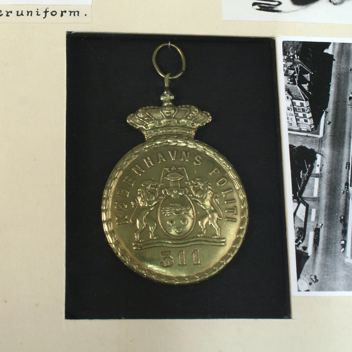 Innrammet utstillingsmontasje med fotokopier fra Politigaarden i København
og kopi av teksten til "Vægternes Natte-Sang" fra København 1825. Kopier av tegninger som forestiller danske vekteruniformer fra 1726, 1784, 1808  og  1862 og danske politiuniformer fra 1807, 1863 og 1865. To danske polititegn i metall fra Københavns politi og Statspolitiet