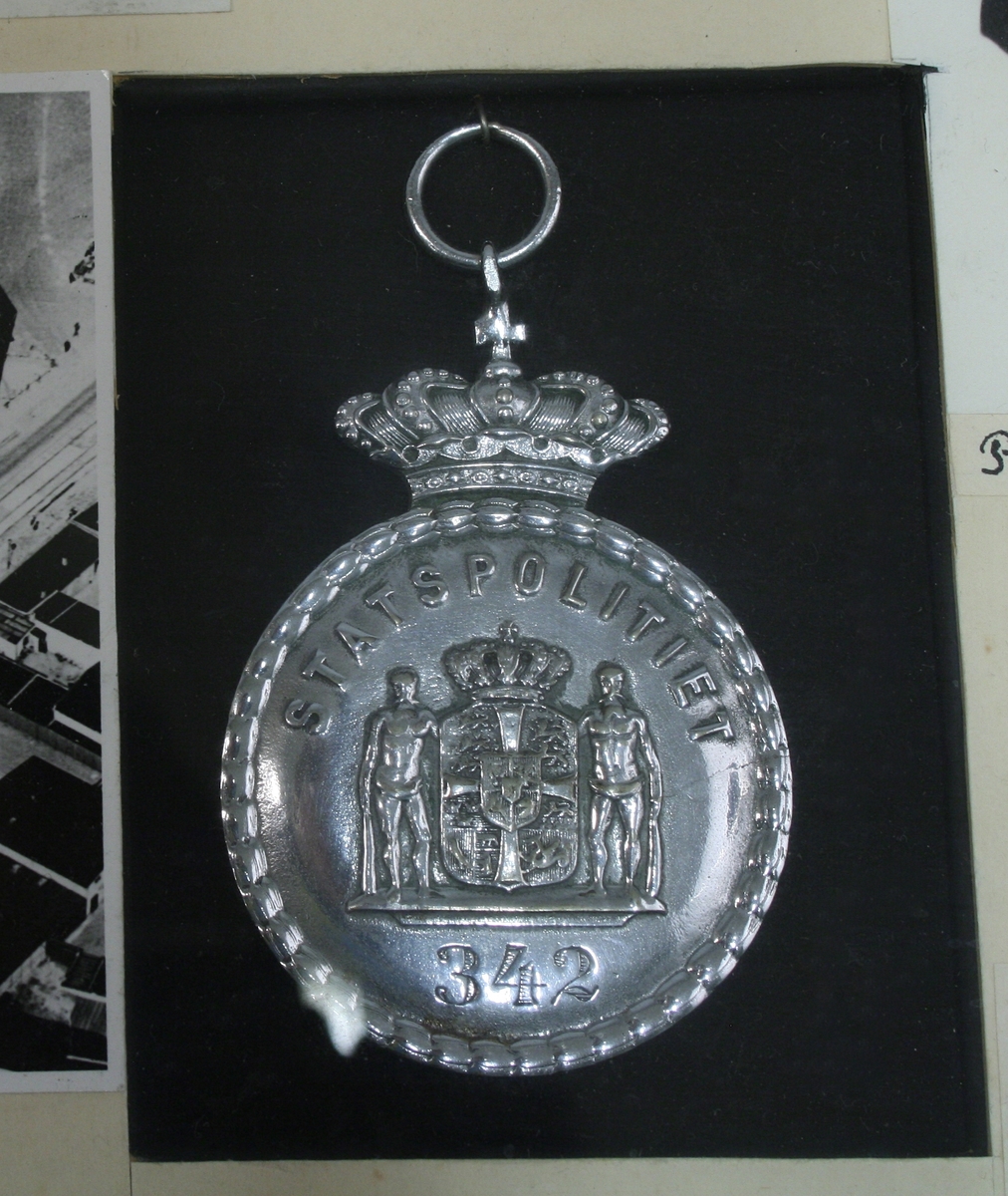 Innrammet utstillingsmontasje med fotokopier fra Politigaarden i København
og kopi av teksten til "Vægternes Natte-Sang" fra København 1825. Kopier av tegninger som forestiller danske vekteruniformer fra 1726, 1784, 1808  og  1862 og danske politiuniformer fra 1807, 1863 og 1865. To danske polititegn i metall fra Københavns politi og Statspolitiet