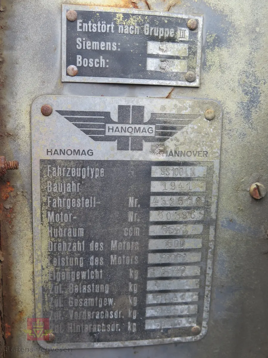 Hanomag SS 100 LN. Ombygd 2 - akslet (4 hjul) maskin med både hydraulisk gravemaskin og lasteskuffe. Gul er hovedfarge (antatt grå originalt). Fra fabrikken ble typen SS 100 LN utstyrt men en vannavkjølt 6-sylindret dieseldrevet motor av typen Hanomag D85S som yter 100 Hk ved 1500 omdreininger. Motorvolum er 8,553 liter. Motornummeret skal være 60386 om motoren er den originale. Maskinens produksjonsnummer er 432528. Girkassen er av typen ZF KB60 med 4 gir framover og ett bakover, pluss overdrive. Topphastighet 65 km/t. Det elektriske anlegget er 24 V. 20 tommers hjul, opprinnelig hadde den tvillinghjul bak. Dører finnes men sitter ikke på.
Har tre merker (stempel) med ørn og hakekors samt plate fra produsenten (på torpedoveggen).
"FROSS-BUSSING" merking i fronten (antatt grill fra en Fross- Bussing).