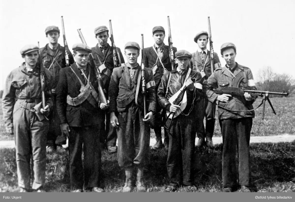 Båstad-tropp av Hjemmestyrkene i 1945. Hvor i Trøgstad? 
Første rekke, fra venstre mot høyre:
Jon Baastad (Røbringen), Johan T. Ruud, Sverre Enger, Ola Kongsbak, Jon Natrud.
Bakre rekke, fra venstre mot høyre:
Alf Løken, Tor Natrud, Einar Nøkleby. Siste mann bakerst er ukjent, men det var en kar som jobbet på Sæter (Nordre Båstad)
Karene har maskinpistol av merket Sten gun, maskingevær av typen Bren gun, Lee - rifle og  US Karabin.