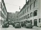 Parkerade Volvo-lastbilar med Nordiska Kompaniets varumärke på dörrarna. 
NK-centrallager invigdes på St Eriksgatan 46 (den tidens gatunumrering) den 4 september, bilden publicerades i Svenska Dagbladet torsdagen 5 september 1940.