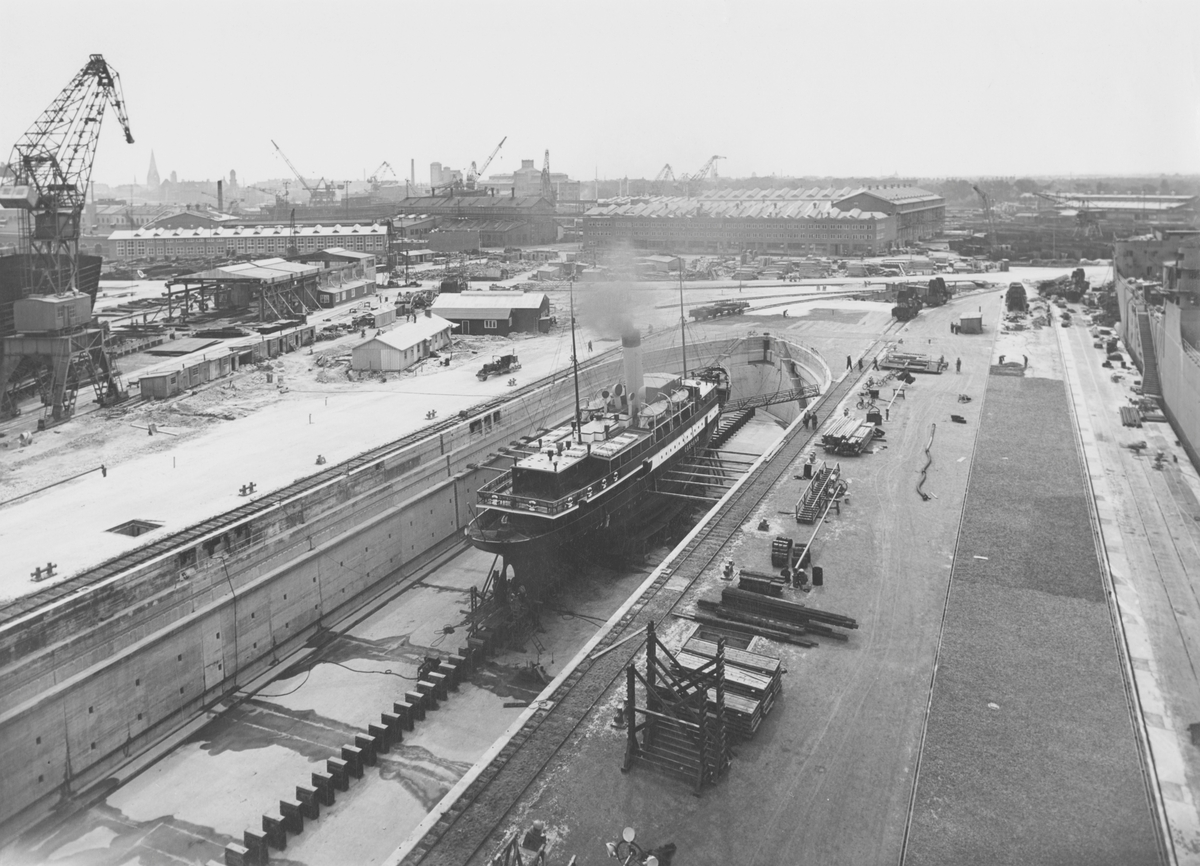 ÖRESUND i docka, 3 sep 1948

Vy över ett parti av varvsområdet på Kockums mekaniska verkstad. I förgrunden passagerarångfartyget Öresund byggt vid varvet 1905 i torrdocka III.