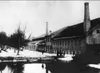 Forsviks bruk. Exteriörbild av bruket år 1906 - 1907. I den svarta stugan under vällingklockan var portvaktsstugan. Pojken i förgrunden är Sven Bremsjö.