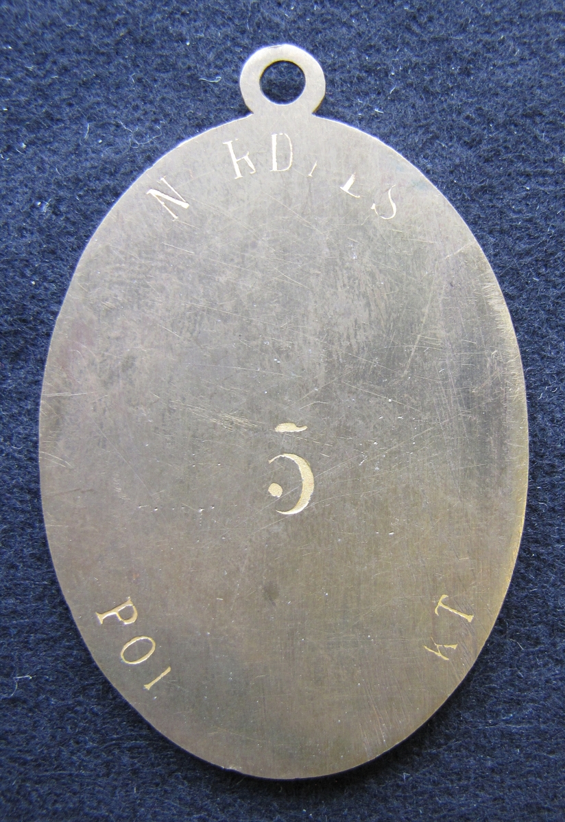Polisbricka, oval med en ögla i toppen. 

På framsidan: Lilla riksvapnet, dvs en krönt sköld med tre kronor. Bakom skölden eklöv och korslagda fasciner. Under emblemet står det POLIS.

På frånsidan: NORDALS POLISDISTRIKT står den i det övre och undre kanten. mitt på står siffran 5. Brickan är mycket sliten så mycket av texten är oläslig.