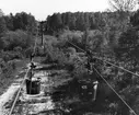 Kalklinbanan Forsby - Köping. Vy över kärret vid Öljaren. Före nästa stolpe i bilden, passeras Forsån, som förbinder Öljaren med Hjälmaren. Linbanevagnar i förgrunden. Bilden tagen från mast 467.