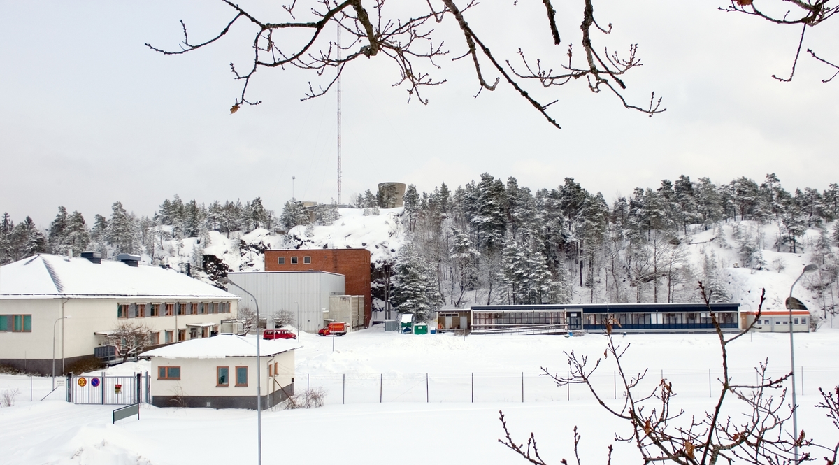 Ågesta kärnkraftverk. Under 2005 gjorde Tekniska museet tillsammans med Stockholms Läns Museum och Länsstyrelsen i Stockholms län en fotodokumentation av Ågesta kraftvärmeverk, Sveriges första kommersiella kärnkraftverk, Foto: Nisse Cronestrand. Bildbeskrivningar: Ingenjör Åke Bergman.
Bilden föreställer: Översiktsbild av Ågesta tagen från ett träd utanför vakthavande ingenjörs bostad. Förklaring av system framgår av rapport: Statens Vattenfallsverk A23/60 5/4 1960.