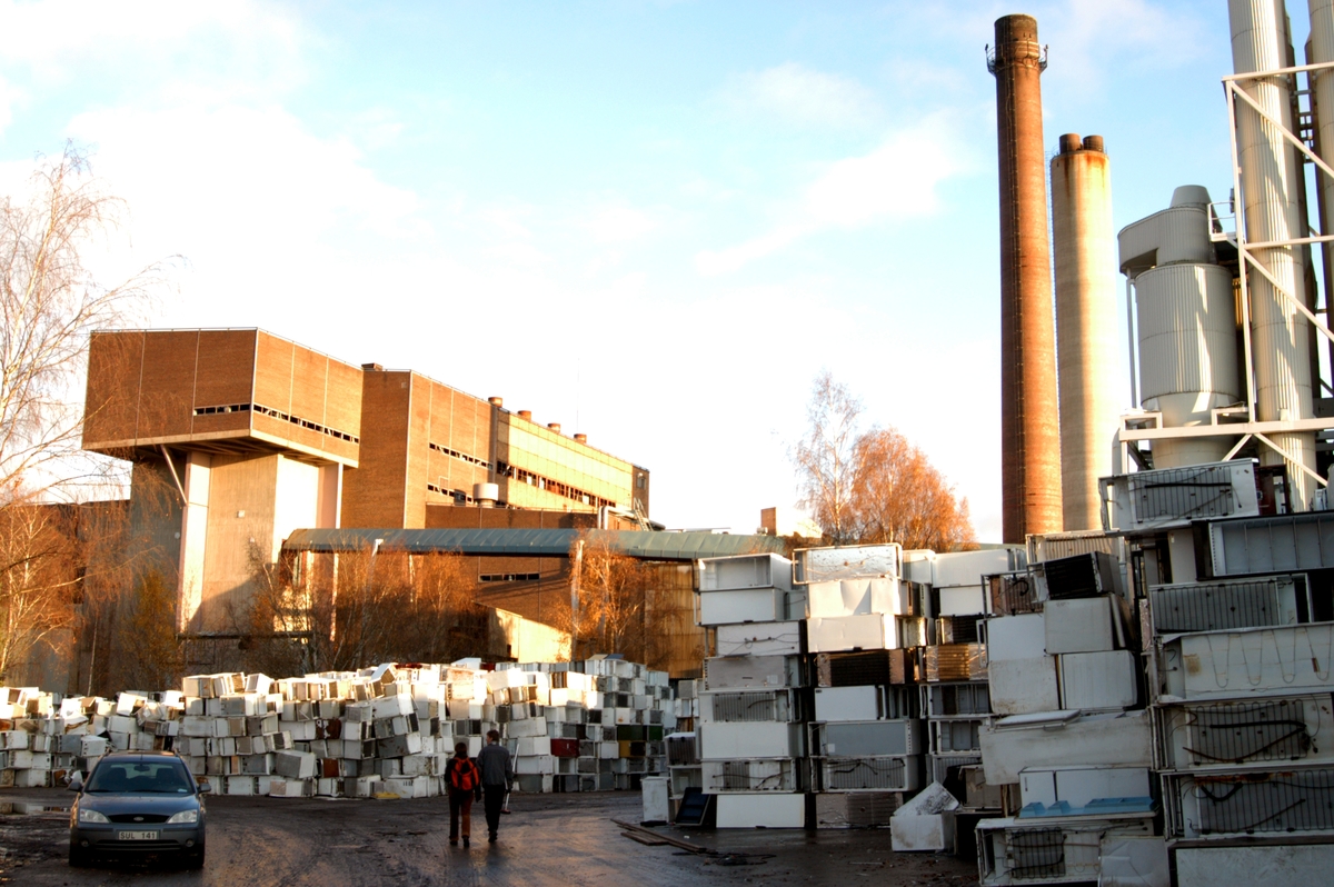 Lövsta dokumentationen: Tre dagar under vinter/vår 2003-2004 dokumenterade Etnolog Peter du Rietz och fotograf Nisse Cronestrand lövsta sophanteringsområde i Hässelby väster om Stockholm. Den omfattar byggnader, miljön, och människor. Den mesta tiden lades på den gamla sopförbränningsanläggningen, miljöstationen och destrution av kyl & frysskåp.
Bildtext: Den gamla sopförbränninganläggningens i bakgrunden med alla kylskåp i förgrunden som väntar på att destrueras.