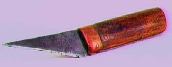 SNICKARE
Kniv med trekantigt blad och holk av koppar vid skaftfogen.
Text i liggaren: "Snick. Rudolf A. Johansson, Skara inrop å aukt. i Skara...Nr 10957-70 tills. 5. kr."
Stämpel å knivbladet i form av en fisk samt texten: E.A. BERG
                                                    ESKILSTUNA
                                                    GARANTI