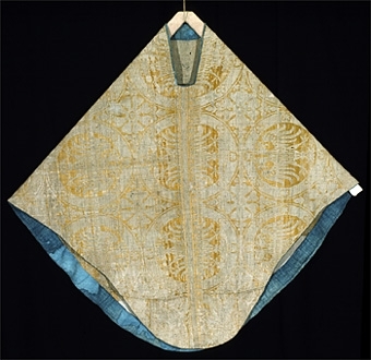 Mässhaken är vävd i s.k. Regensburg-brokad. Dubbelt varpsystem med lin och silke, botteninslag av silke samt mönsterinslag av tarmguld spunnet runt en lintråd. (Taquete alt. samitum)
Tarmguldet är idag bortnött.

Mönstret i form av dubbelörnar inom cirklar har stark anknytning till italiensk-bysantinska mönster. 

Enligt A. Geijer tillverkad i Spanien eller Tyskland.

Litteratur: Medeltida vävnader och broderier i Sverige.
av A. Branting och A. Lindblom. del II, plansch 217, text sid 101 ff.
"Ur Textilkonstens historia", Agnes Geijer. 1972. (sid 162, pl 34 a.)