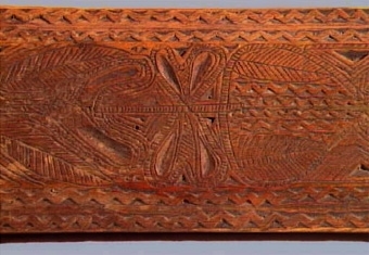 Mangelbräde med skulpterat, hästformat handtag. Karvsnittsdekor i form av rosett, virvelhjul, hjärta. Ristade bladornament, rutmönster mm. Uddsnittsbårder utmed långsidorna bl.a.