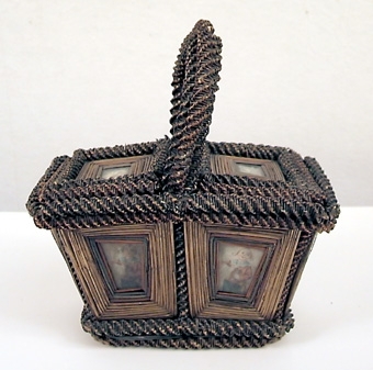 KORG, REKTANGULÄR, HANDTAG, TVÅ LOCK. ÅTTA ST INGLASADE BILDER PÅ LOCKEN OCH SIDORNA. GLAS UNDER BOTTEN. RUNT MOTIVEN FINNS STRÅN SOM I SIN TUR ÄR OMGIVNA AV RINGLANDE BUNDNA STRÅN.