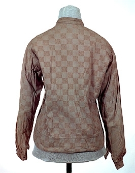 Ljust brunaktigt vit blus sydd av tuskaftsvävt bomulltyg med tryckt mönster i färgerna brunt och ljust blått. Blusens framstycken är fodrade med ett ofärgat bomullstyg medan bakstycket är fodrat med ett röd och vitrutigt tyg. Blusens olika delar är sammanfogade med maskinsöm, kastsöm och förstygn. Knäppning mitt fram av tryck knappar. Ärmarna är avslutade med en manschett som knäpps med en tryckknapp.


Neg.nr: 
Sakord: BLUS
Tillverkningstid: 1920 - 1930
Material: Bomull
Teknik: Vävt tryckt sytt
Mått: L=570
Vikt: