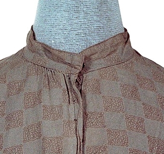 Ljust brunaktigt vit blus sydd av tuskaftsvävt bomulltyg med tryckt mönster i färgerna brunt och ljust blått. Blusens framstycken är fodrade med ett ofärgat bomullstyg medan bakstycket är fodrat med ett röd och vitrutigt tyg. Blusens olika delar är sammanfogade med maskinsöm, kastsöm och förstygn. Knäppning mitt fram av tryck knappar. Ärmarna är avslutade med en manschett som knäpps med en tryckknapp.


Neg.nr: 
Sakord: BLUS
Tillverkningstid: 1920 - 1930
Material: Bomull
Teknik: Vävt tryckt sytt
Mått: L=570
Vikt: