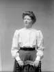 Ateljé. 
Ester Isaksson, *1888. Syster till smederna i Hudingsbacken. 
Fotograf: Ellen Kock? Axel Lundbäck m.fl.
Gullspångssamlingen.
Bilder från Gullspång med omnejd.