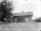 Exteriör. 
Litet trähus, två herrar framför. 
Gullspångssamlingen.
Bilder från Gullspång med omnejd.