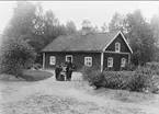 Forsvik, herrgårdkusken Oscar Kihlström med familj utanför bostaden, omkr 1902 - 03. Förstoring 38 x 40 cm.