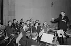 Skara Orkesterförening 1950. 
Dirigent musikdirektör Åberg, Skövde.
Första raden från vänster: 
Allan Larsson, Gunnar Storm, Olle Engdahl. Andra raden från vänster: 
Erik Boethius och Olle Wickström, Lidköping.