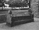 Husaby socken. 
Husaby kyrka, gravkista vid västgaveln. 

Gravmonument av romansk karaktär. Består av fem delar, med gavelkors, sidohällar och kistformad lockhäll. Ytterkanterna på gavelkors och sidohällar tros ha legat kant i kant ursprungligen, så lockhällen är antagligen inte den ursprungliga. Den är smyckad med mycket detaljrika reliefer och på ena gavelkorset en enkelt utformad runristning. 
Ur 