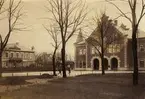 Skara station från Järnvägsgatan omkring 1920. Mellan stationshuset och Järnvägshotellet ser man Ida Dahlqvists lilla kiosk.