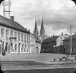 Skyltar vid torget:
Guldsmed Carl Johan Lyberg,
Sandén & Ekegren,
K E Ullberg, Bleck o Plåtslageri,
Fredrikssons Hembageri,
Johan Schödin, Borstbinderi o Korgaffär,
Collin,
Hildegard S......, Tapisseri o Modeaffär