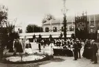 Utställningen var uppbyggd på Läroverkets skolgård.
Huset i bakgrunden är Läroverkets gymnastiksbyggnad.
Mannen till höger i uniform är stinsen i Vinninga, Frans Svensson, född 1849 i Skara.