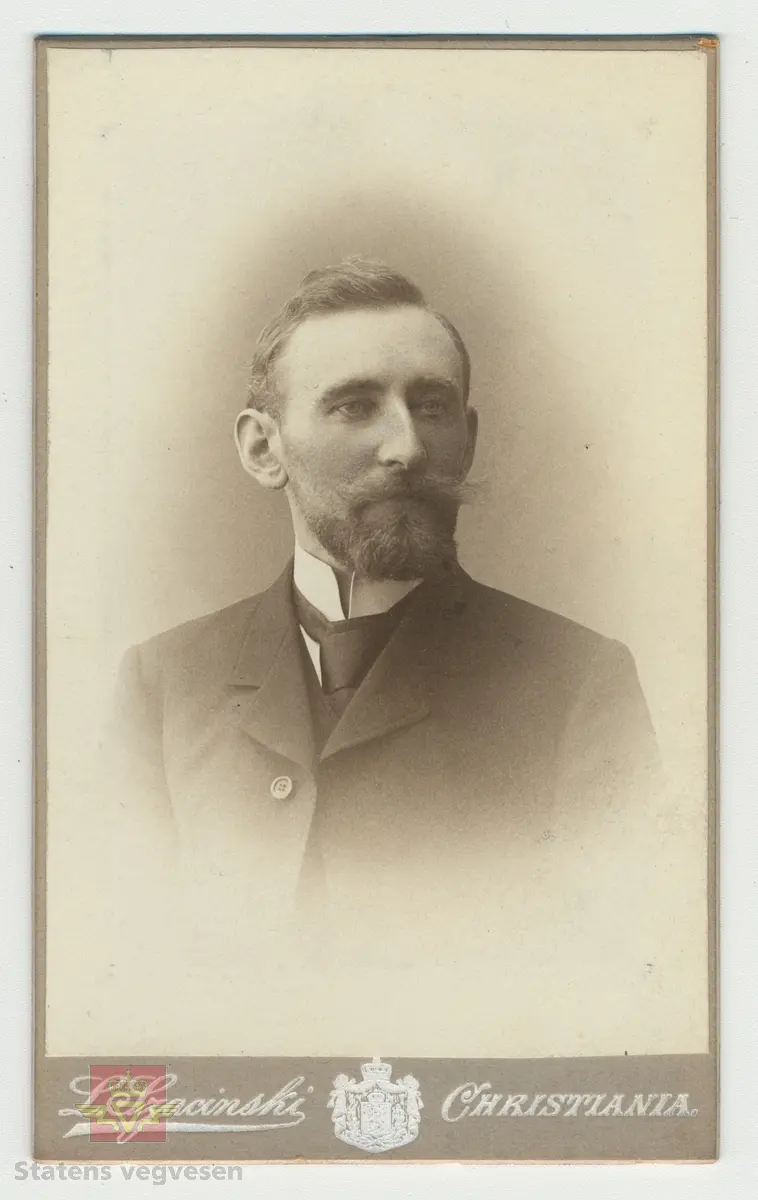 Håndskrevet tekst på framsiden av bildet: "Tilhører Baalsrud (Fra V.D. Krag) 1903." Videre medfølger det håndskrevet tekst til bildet: Sitat: "Krag og Vegdirektør Bergh prøver rullekjerre, bygget for billige veger." Bildet viser presentasjon av rullekjerren, som skulle bli det nye kjøretøyet for høyfjellsvegene, men ikke ble noen suksess. 
Dette bilde er vistnok tatt i et gårdsrom i Haugesund. Til venstre sitter daværende vegdirektør Bergh og til høyre seinere vegdirektør Krag. Usikkert når bilde er tatt, Christian Wilhelm Berg døde i 1873 så bildet er tatt før den tid, og det er trolig det eneste fotografiet vi kjenner hvor Christian W. Bergh er avbildet. Følg pilen til høyre for flere bilder. I alt 7 bilder.
Ref. til "Meddelelser fra Veidirektøren," nr. 2-1945, side 24, der bildet er illustrert i en artikkel om "Rullekjerren," av H.W. Paus. 
Ref. til "Årbok for Norsk vegmuseum 2016," en artikkel om Vegdirektør Krag - "Heller en tarvelig vei enn ingen vei," ved Ane Cecilie Røed. I boka er samme bildet side 101 som i "Meddelelser fra Veidirektøren," nr. 2-1945)
Utsnitt fra Ane Cecilie Røed sin artikkel:
Rullekjerren
"Som vegmann var Krag opptatt av nye ideer og initiativ for å bedre framkommeligheten. Han var også interessert i ulike framkomstmidler noe denne historien illustrerer. Befolkningen i Skjåk hadde lenge ønsket seg en kjøreveg over fjellet til Vestlandet, og da gjerne til Tafjord. Krag på sin side ville at vegen, en simpel kjøreveg, skulle gå over Grotli og slik ble det. Da vegen var nesten ferdig, viste det seg at man ikke kunne kjøre på den med vogn. Til det var vegdekket for løst og vegen for smal. En rullekjerre, som enten var en kjerre med to brede hjulfelger, eller en trommel eller rulle, ble lansert og ble begeistret støttet av Krag.  Det sies om rullekjerren at den allerede i begynnelsen hadde det med å løpe løpsk og rulle sine passasjerer omkull. Da vegdirektøren og ordføreren skulle prøvekjøre den nye farkosten, endte de i grøften, med bygdefolket som nysgjerrige tilskuere. Kort tid etter var rullekjerren en saga blott, og på den nye vegen kjørte man med bredfelgede kjerrer (Schulerud 1974 s 301-302). Historien om rullekjerren bekrefter på lik linje med andre episoder i denne artikkelen, Krags brede interessefelt og engasjement. "
Se artiklene i Nedlastinger og Referanser lenger ned på siden.
Et eget Vegdirektorat kom først i 1864, og Christian Wilhelm Berg var den første vegdirektør i perioden 1864 - 1873.
Etterfulgt av  Hans Hagerup Krag i 1874 - 1903,  Johan Christian Skougaard 1903 - 1918 og Andreas Baalsrud i perioden 1919 - 1945. 
Bilde 2) Vegdirektør Christian Wilhelm Bergh.  Bilde 3) Vegdirektør Hans Hagerup Krag. Bilde  4) Vegdirektør Johan Christian Skougaard. Bilde 5) Vegdirektør Andreas Baalsrud. Se vedlegg i Nedlastinger for mer informasjon.
Bilde 6) Rullekjerren.  I følge «Meddelelser fra Veidirektøren Nr. 2-1945, side 24, er dette bilde av rullekjerren tegnet av overingeniør Fenger Krog.
Bilde 7) Informasjon om rullekjerren ved Norsk vegmuseum sin første utstilling 1992.