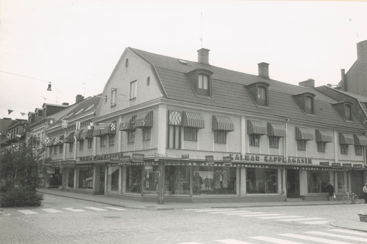 Affärsbebyggelse med markiser. Fasad mot Storgatan - Larmgatan, Kvarnholmen väster om Västra Sjögatan. Bilderna är tagna inom ramen för Kalmar kommuns inventering av Kvarnholmens bebyggelse 1970-1971 och skänkta till länsmuseet.