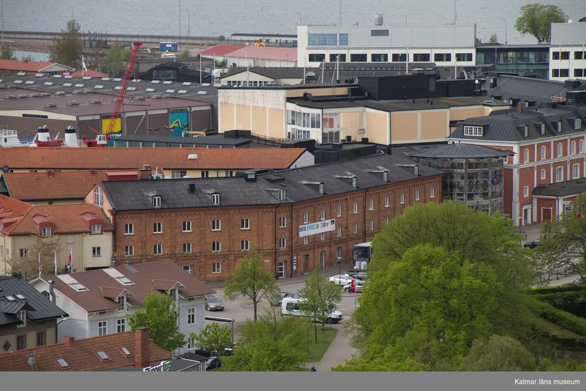 I förgrunden Baronens köpcentrum med Hotell Packhuset nere till vänster i den gula byggnaden. Mitt i bilden Barlastholmen
med Kalmar Marina med fd Arlas ostlager i betongelement byggnaderna. I övre bildkant Linné universitetet.
Under fasadrenoveringen av delar av Ångkvarnen 2014 fick Kalmar läns museums fotograf möjlighet att ta foton från byggnadsställningarna runt tornet. Så här såg centrala Kalmar ut från 60 meters höjd den 14 maj 2014.