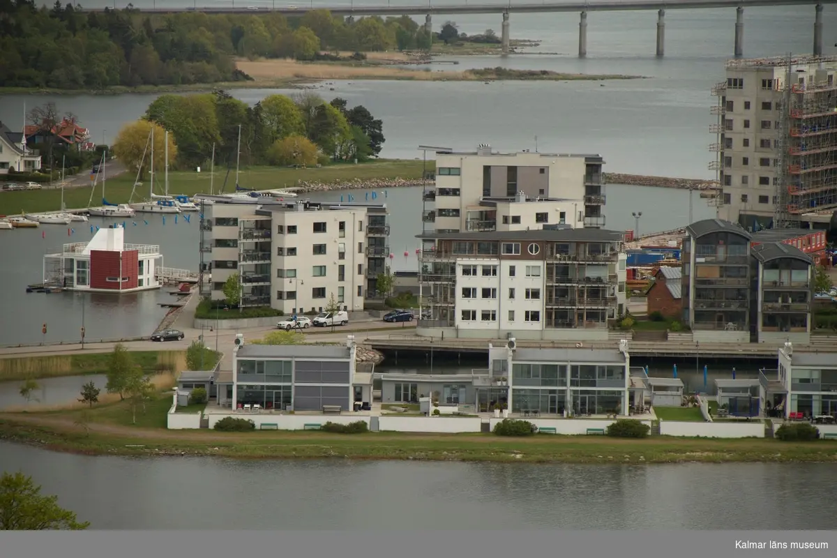 Stadsdelen Varvsholmen med Ängö hamnbassäng, Ölandsbron i fonden. 
Under fasadrenoveringen av delar av Ångkvarnen 2014 fick Kalmar läns museums fotograf möjlighet att ta foton från byggnadsställningarna runt tornet. Så här såg centrala Kalmar ut från 60 meters höjd den 14 maj 2014.