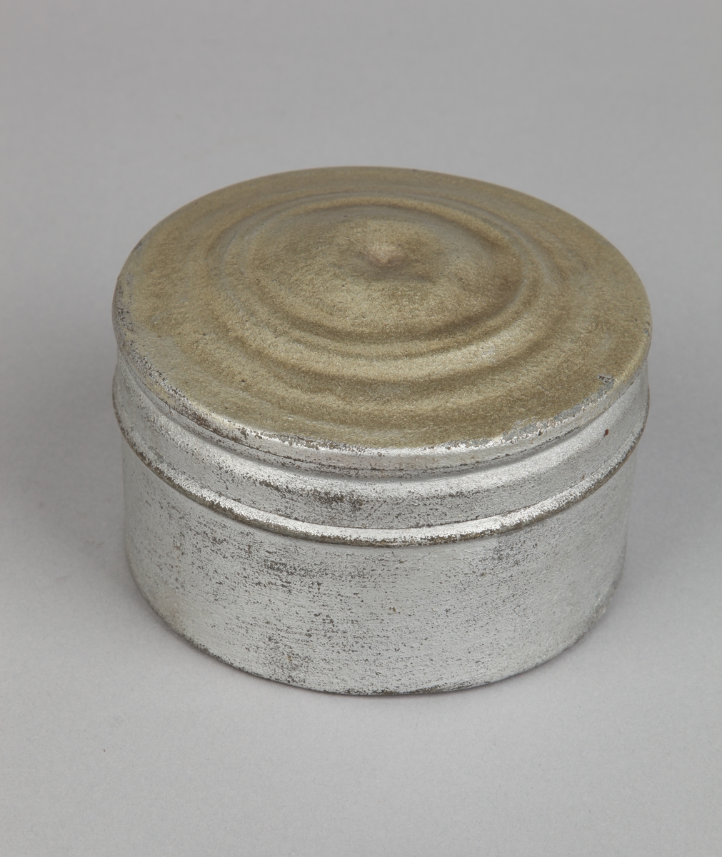 Rundt luftkompass i metallboks med lokk. Kompass-rose i papir.