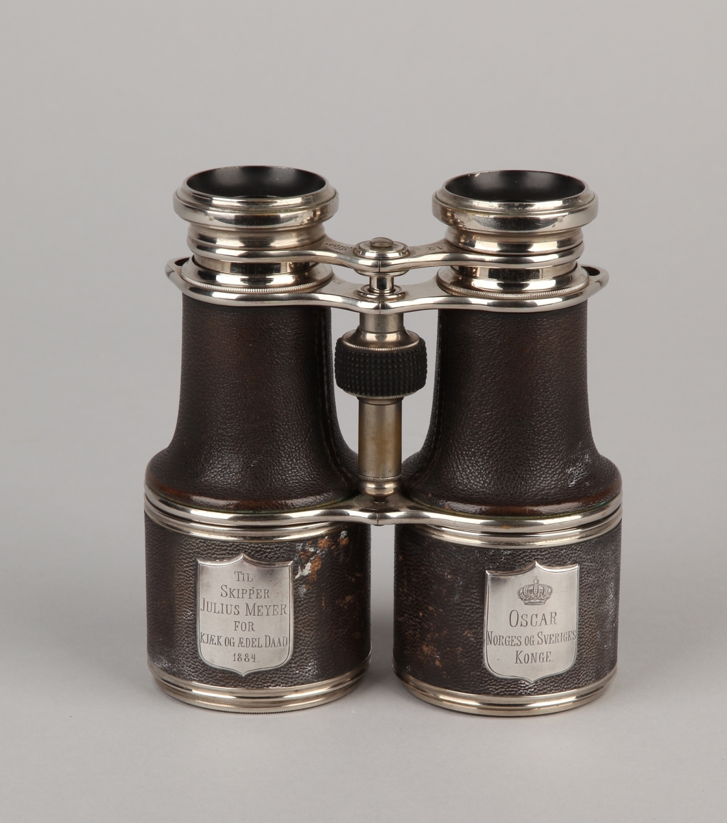 Kikkert gitt fra Oscar, Norges og Sveriges konge til skipper Julius Meyer i 1884.  Med to linser, fokusering ved å dreie lite ratt mellom linsene. I læretui.