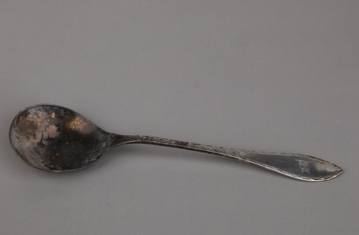 Skje i nysølv med rederiflagg NBAD.