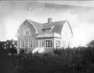 Villa i Åsen, Karlsborg. Huset byggdes av Ernst och Klara Nilsson (född Sjöberg) i slutet av 1920-talet. 1956 köptes huset av Klaras systerdotter Astrid Erenroth och hennes man Ernst Andrén. Elsa och Gösta Zettergren sålde år 2001, efter att ha varit ägare till huset i många år, till Rickard Irenheim. Glasnegativ finns.