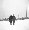 En man och en kvinna promenerar i snön.