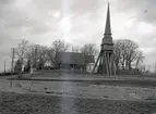 En klockstapel, kyrkogård och kyrka. Pelarne kyrka.