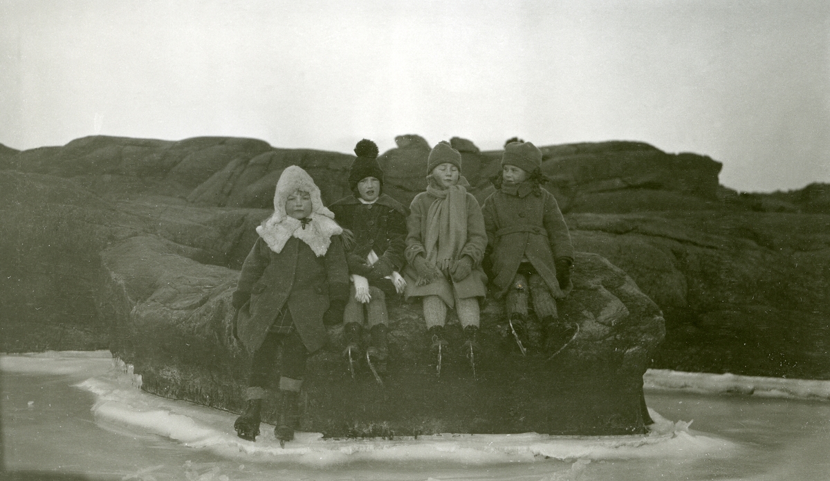 Fire jenter med skøyter på bena sittende på svaberg i Fredriksvern (Stavern). Fra venstre: Ann Margrete Larsen, Lilly Hummel, Else Schrøder og Ingjerd Aronsen.