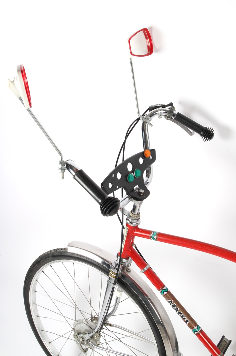 Rød guttesykkel med trippel gir. Sykkelen har to speil og et "dashbord" med reflekser montert på styret.