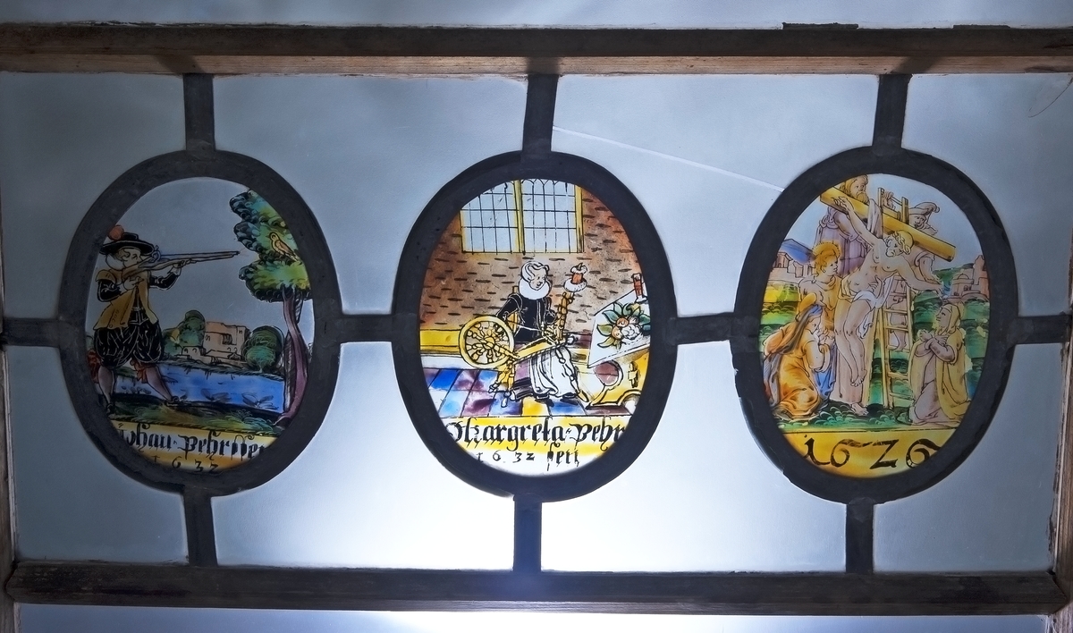 Fönster, med tre målade glas: en man som skjuter mot en fågel i ett träd; en kvinna vid spinnrock; Kristi korsnedtagning. De ha följande text: Johan Pehrssen 1632; Margareta Pehrssen 1632; 1626.
Målningarna (ovaler) äro 13,5x17cm.
Från Nor, Storviks Hammarby, Ovansjö sn, urspr. i en gård i Stocksbo by, Ovansjö. Den förste nybyggaren i Stocksbo var Pehr Andersson; efter honom nämnes som ägare Johan Pehrsson, som sannolikt är P.A.s son. J.P. var gift 2ggr, andra ggn m. Marit Pehrsdotter, d. 1656.