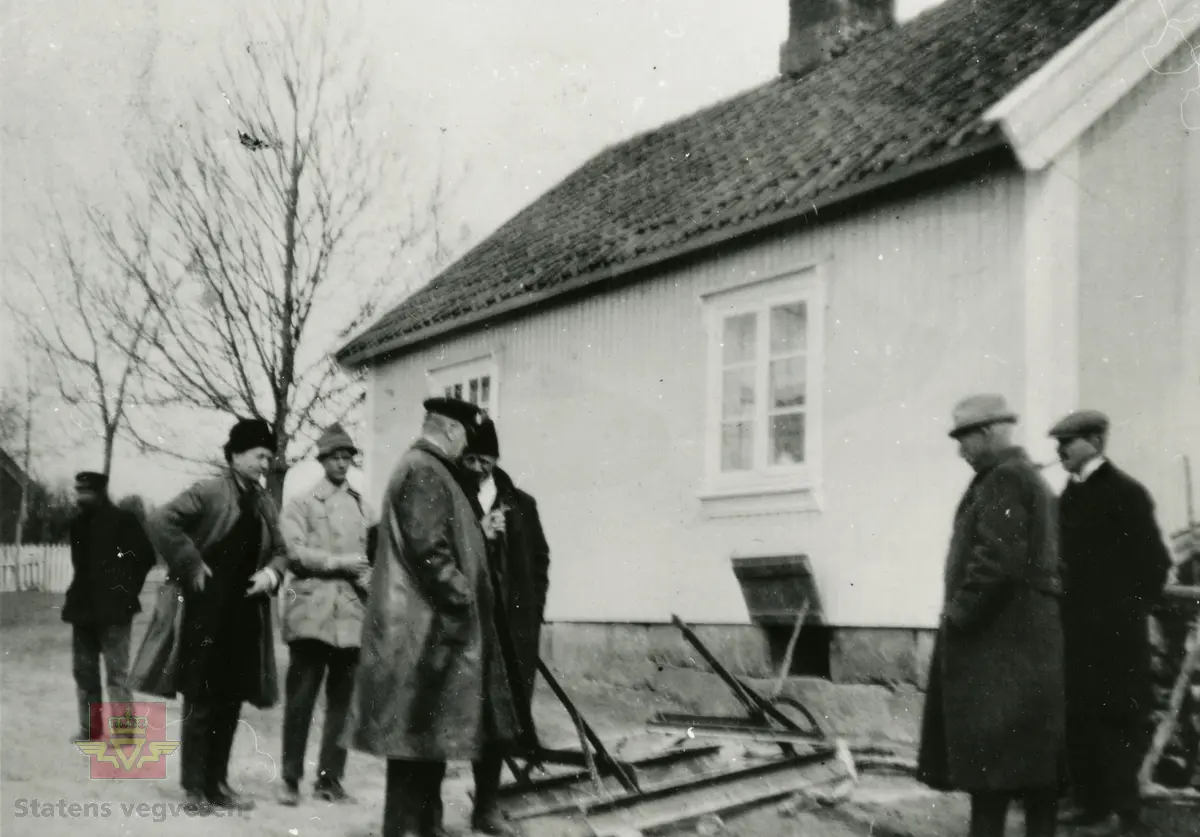 Amerikansk veghøvel "Russel Grader"  i arbeid i Østfold 1924, i følge merking.  Ref. til "Meddelelser fra Veidirektøren", Nr. 47-mai 1924. Artikkel om "Prøve med den amerikanske veihøvel "Russel Grader" samt skrapning av veibanen med "Western" skrape", av overingeniør Thor Olsen. Befaring  med vegdirektoratets og Østfold fylkets ingeniører.  Andre bilder av veghøvelen som er illustrert i artikkelen vises i bilde 2/5 og 3/5. Bilde 4/5: "Skraperne av "Western"-typen forarbeides som nævnt ved fylkets verksted og utstyres nu med en fast arm paa den ene side for styring av hele redskapen foruten den bevægelige for stillingen av bladene , som det vil sees av fig. 5". Bilde 5/5: Vedlikeholdsarbeid med amerikansk vegskrape utføres i Østfold.